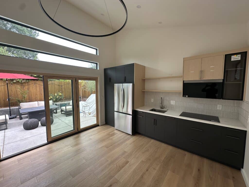 The finished ADU kitchen with vaulted ceilings and folding doors to the patio — livable square footage worth more than the garage it replaced.