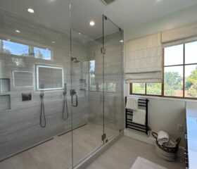 Frameless glass, a linear drain, and no threshold to step over. Curbless walk in shower in Mill Vally, Marin County, with frameless glass and large format gray tile in an East Bay primary bathroom remodel