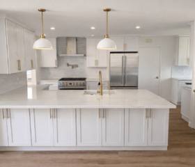 A spacious kitchen designed for modern family living. Luxury white kitchen in Larkspur, CA, with oversized island, paneled cabinetry, and premium appliances.