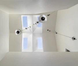 Overhead view of sculptural skylights and pendant lights. Alamo Overhead view of geometric skylights and pendant lighting in a modern stairwell.