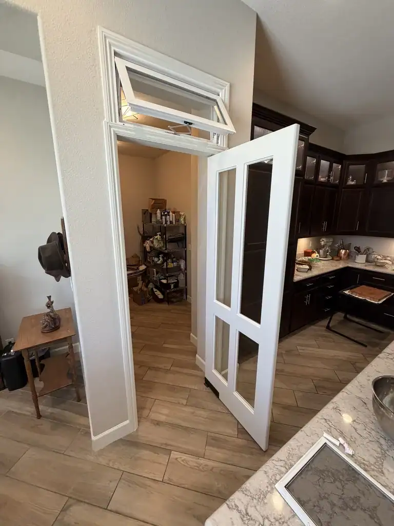 The same pantry door swung open in the opposite direction toward the kitchen, showing that it operates from either side.