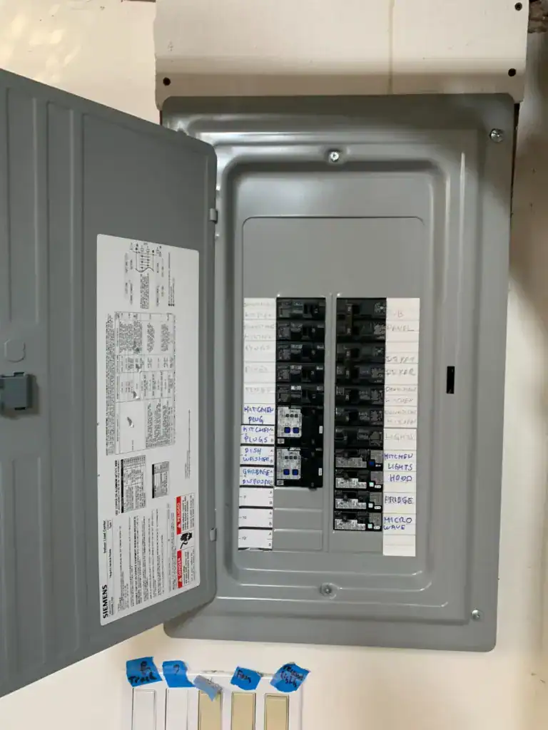 Load center directory showing dedicated circuits for kitchen plugs, dishwasher, disposal, hood, refrigerator, microwave and kitchen lights
