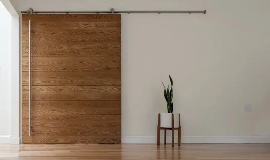 Modern oak wood sliding barn door in a contemporary home interior